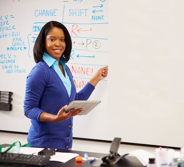 Science Teacher Standing At Whiteboard With Digital Tablet